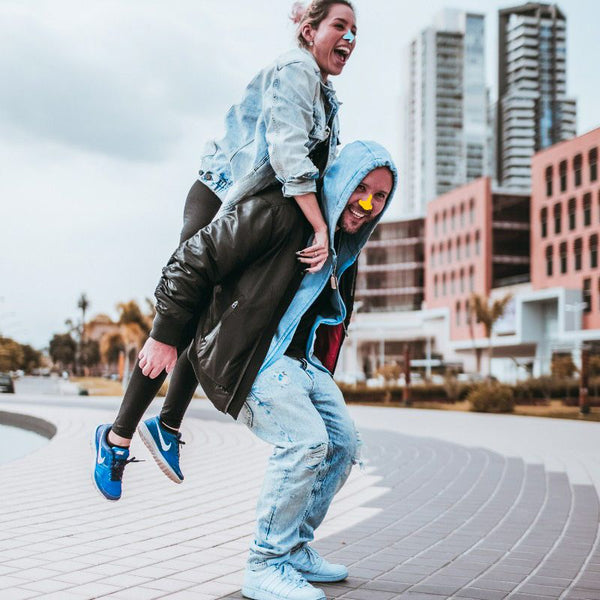 Couple having fun wearing colorful sunscreen